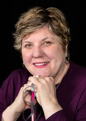 Close-up portrait photograph of Patricia Flatley Brennan, RN, Ph D. smiling with clasped hands under her chin.