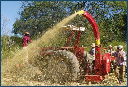 Community members gather and grind corn with grinding machine