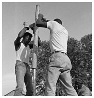 Two men dig hole for a water pump