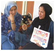 BRAC community health worker shows illustration chart to a group of women