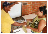 Fome Zero member gives container of milk to city resident