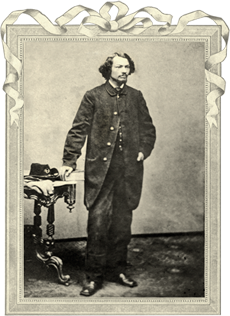 Black and white photograph of a bearded man standing beside a table wearing a long coat with one hand resting on the table where a military hat and gloves rest. Courtesy Anne Straith Jamieson Fonds, The J. J. Talman Regional Collection, The University of Western Ontario Archives.