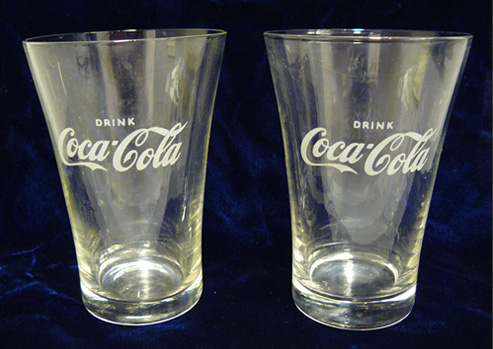 Photograph of two glasses with “Drink Coca-Cola” etched on them.