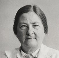 Dr. Dorothy Hansine Andersen, a White female in a lab coat holding papers posing for her portrait.