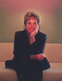 Dr. Molly Joel Coye, a White female in professional attire seated and posed with her head in her hand.