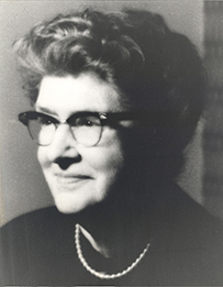 Dr. Louise Eisenhardt, a White female with glasses and short hair gazing to her right for her portrait.