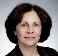 Dr. Judith Flores, a Latina female in a dark jacket posing for her portrait.