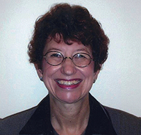 Dr. Janet Rose Osuch, a White female wearing glasses and collared blouse, smiling for her portrait.