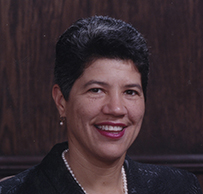 Dr. Deborah Prothrow-Stith, a smiling African American female in pearls posing for her portrait.