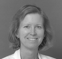 Dr. Diane Gail Snustad, a White female in her lab coat, smiling for her portrait.