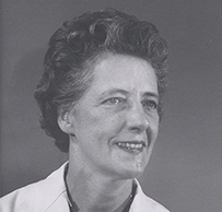 Dr. Anna Lenore Skow Southam, a White female with short hair in her lab coat posing for her portrait.