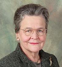 Dr. Mary Ellen Beck Wohl, an elderly White female with glasses in professional attire posing for her portrait.