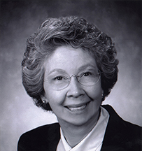 Dr. Sara Ellen Walker, a female in professional attire and glasses posing for her portrait.