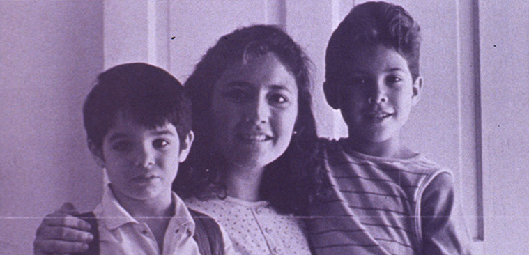 A woman stands with two boys