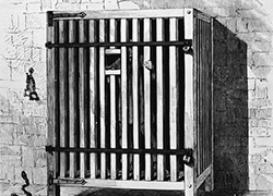 An illustration of cell made of wooden slats raised up off the floor, with a small square opening at head height, fastened closed with bars and padlocks.